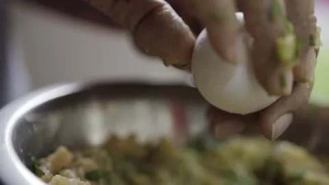 Hand cracking egg into chicken mixture in bowl during meatball preparation Stock Footage 334622323