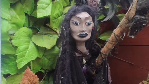 Hand crafted Witch on a broom hanging against fabric leaves Stock Footage 328233312