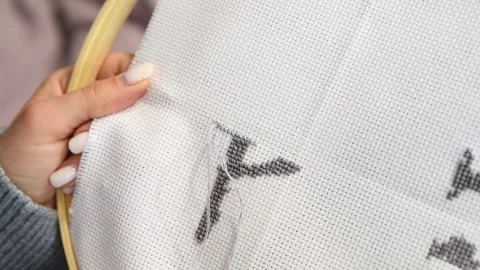 Hand crafting black thread letter y cross stitch on white fabric hoop in na.. Stock Footage 334955193