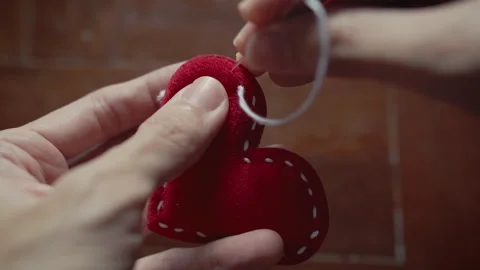 Hand-Crafting a Red Heart Shape from Textile Material Stock Footage 330927230