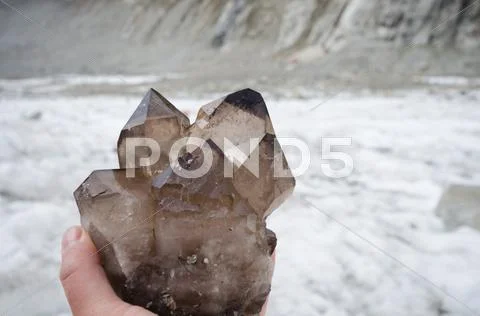 Hand of cristallier holding gemmy cluster of smoky quartz crystals Stock Photos