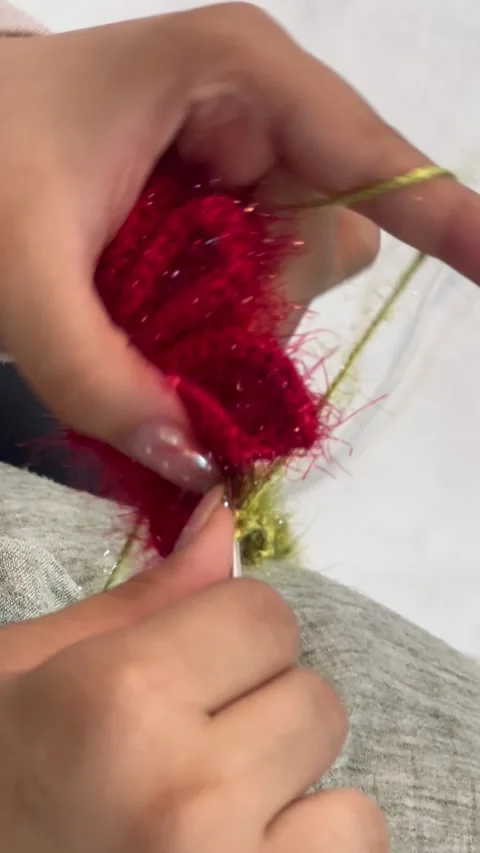 Hand crocheting red fluffy yarn with hook, vertical close-up shot Stock Footage 345166889