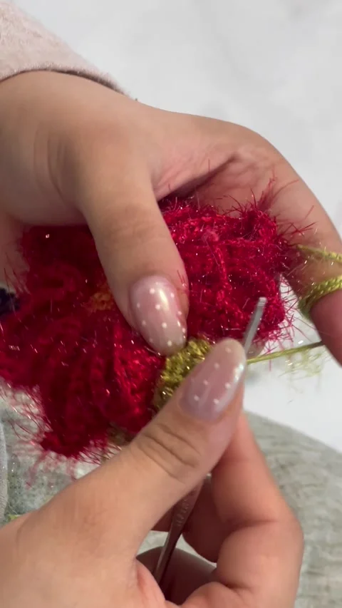 Hand crocheting red fluffy yarn with hook, vertical close-up shot Stock Footage 345166933