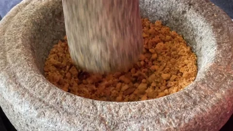 Hand Crushing And Grinding Roasted Peanuts In Stone Mortar Stock Footage 332837369