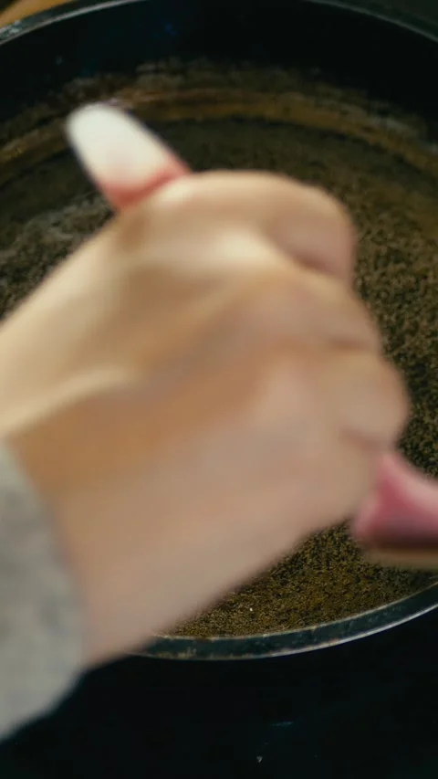 Hand with culinary brush applies vegetable oil to hot frying pan, vertical shot Stock Footage 262252927
