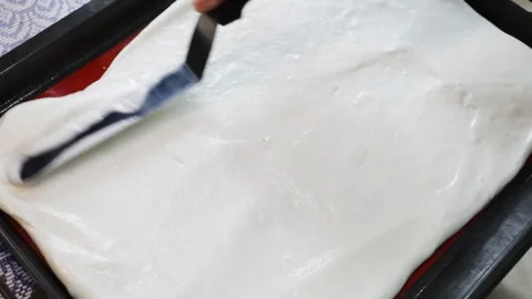 Hand with culinary turner aligns whipped whites on baking sheet, slow motion Stock Footage 276363885