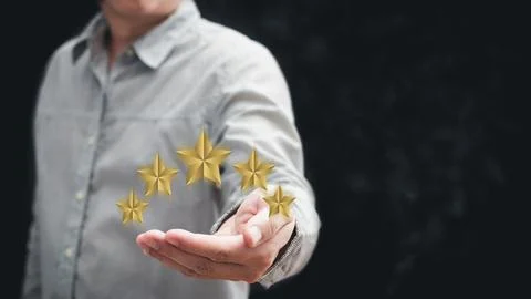 Hand of customer or client holding the stars to complete five stars with co.. Stock Photos