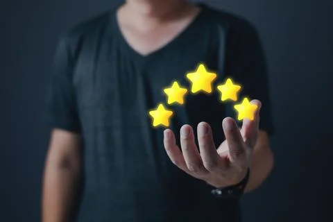 Hand of customer or client holding the stars to complete five stars with co.. Stock Photos