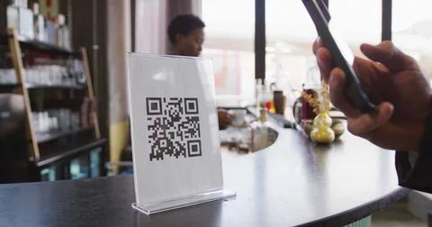 Hand of customer using smartphone to read qr code on the bar at a cafe 스톡 사진