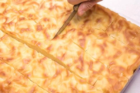 Hand cut with a knife traditional Bulgarian pie in pieces Stock Photos