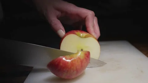 Hand cuts apple in half close up Video stock 164005812