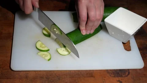 Hand cuts cucumber on cutting board Stock Footage 141546025