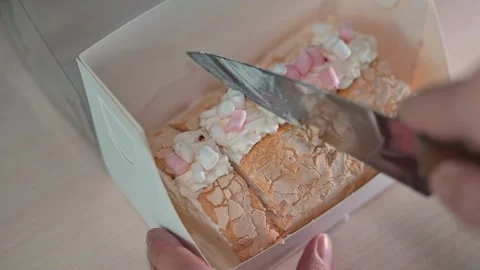 A hand cuts a dessert into portions using a knife on a flat surface. The dessert Video stock 338188224