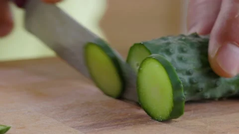 Hand Cuts With Knife Cucumber On the Table In Kitchen Stock Footage 157994320