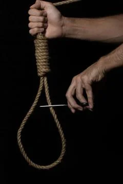 A hand cuts a loop with scissors on a black background. Searching of decisions.  Stock Photos