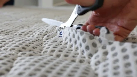 The hand that cuts a material with scissors, located on the cutting table Stock Footage 129936561