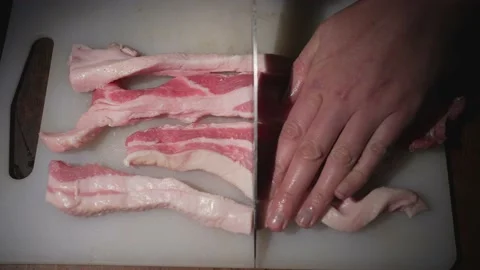 Hand cuts multiple fresh pork belly bacon POV close up Stock Footage 164006079