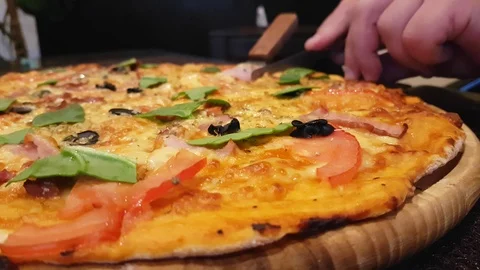 Hand cuts a pizza with a knife Stock Footage 87795363