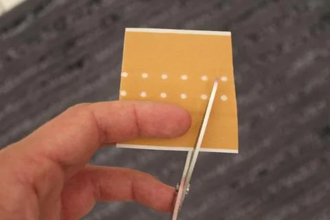 Hand cuts a plaster with scissors Stock Photos