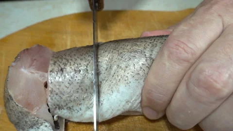 Hand cuts raw fish with a knife in slow motion Stock Footage 136897365