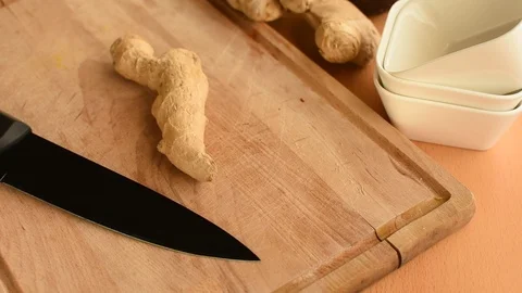 Hand cuts slices from a ginger root with the household knife Stock Footage 123145780