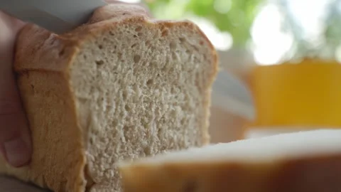 Hand cuts soft bread slice with knife Stock Footage 337434092
