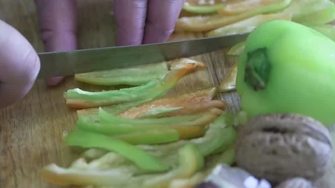 Hand cuts vegetable pepper on a cutting board, close-up Vídeos de archivo 220272099