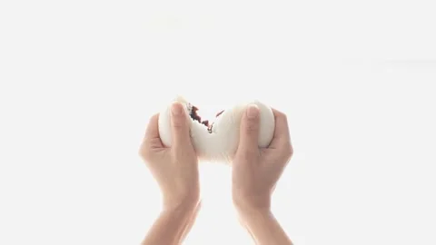 A hand that cuts the warm bread with red bean paste in half. Stock Footage 165393256