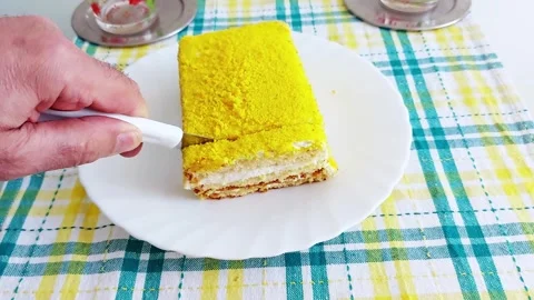 Hand Cuts Yellow Layer Cake on Plaid Table-Slice Revealed Video stock 312444512