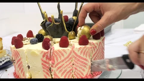 Hand cutting a birthday cake close-up of a person cutting a cake Stockbeeldmateriaal 220660100