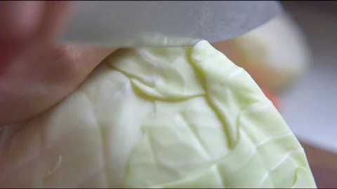 Hand cutting cabbage with knife in the kitchen Vídeos de archivo 76140064