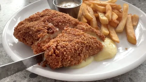 Hand cutting chicken cordon bleu with mozarella cheese melting flowing out Vídeos de archivo 287582598