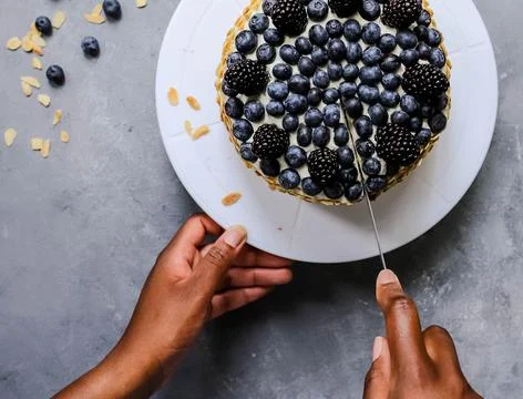 Hand cutting a fruit cake 写真素材