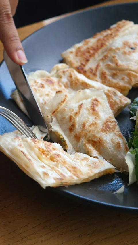 Hand cutting a paratha on a palte  Vídeo Stock 297730778