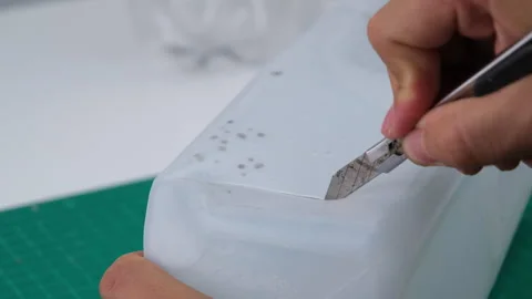 Hand cutting a plastic bottle with a cutter to grow plants or vegetables inside. Stock Footage 248750818