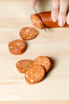 Hand cutting sausage Stock Photos
