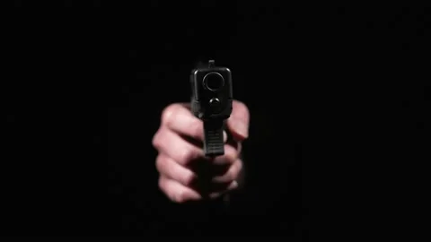 Hand in dark puts down gun Video stock 152916110