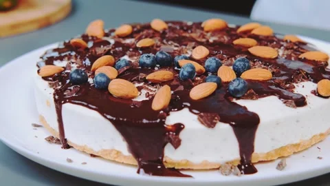 Hand Decorating Layered Cake with Blueberries and Almonds Indoors Stock Footage 342869200