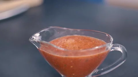 Hand decorating red tomato sauce in glass bowl with basil leaf. Beautiful Stock Footage 135247053