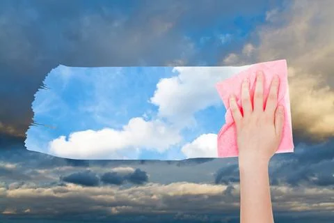 Hand deletes dark cloudscape by pink cloth weather concept - hand deletes ... Foto stock