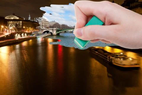 Hand deletes night scenery of Paris city by eraser Stock Photos