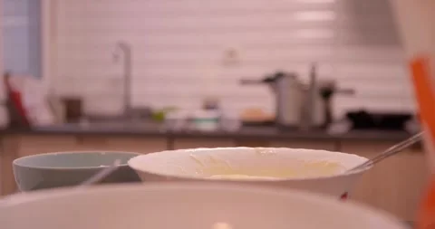 A hand delicately cracking an egg into a mixing bowl. Stock Footage 331398896