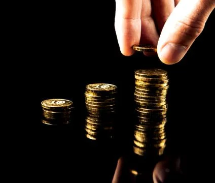Hand deliver a stack of coins graph profit growth on black background Stock Photos