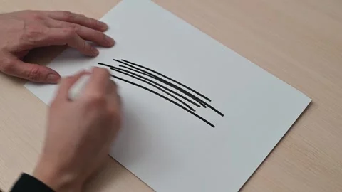 A hand demonstrates different drawing techniques using a marker on paper. The Stockbeeldmateriaal 337549887