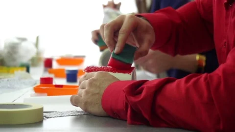 Hand of designer making sponge pattern on a ceramic mug. Creative Workshop. Stock Footage 72396463
