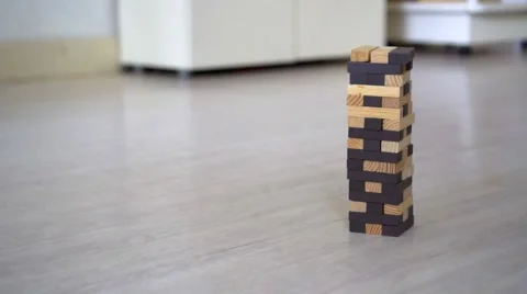 Hand destroying Jenga Tower in the room Stock Footage 68736902