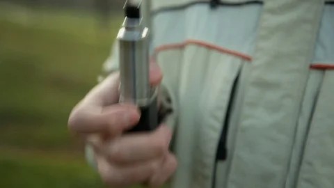 Hand with device of vaping young man in the park in the evening Видео 121061749