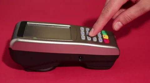 Hand dialing pin code on pin pad of pos terminal on red background. Stock Footage 65395792