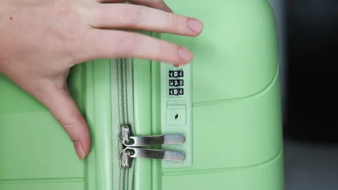 A hand dials the combination into the travel cases padlock. Stock Footage 311562554