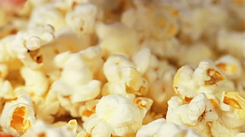 Hand digs into the bucket full of popcorn in search of the perfect piece. Stock Footage 65113988